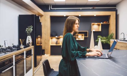 Une cuisiniste travail sur son ordinateur dans une cuisine