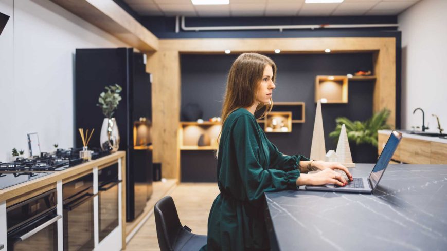Une cuisiniste travail sur son ordinateur dans une cuisine